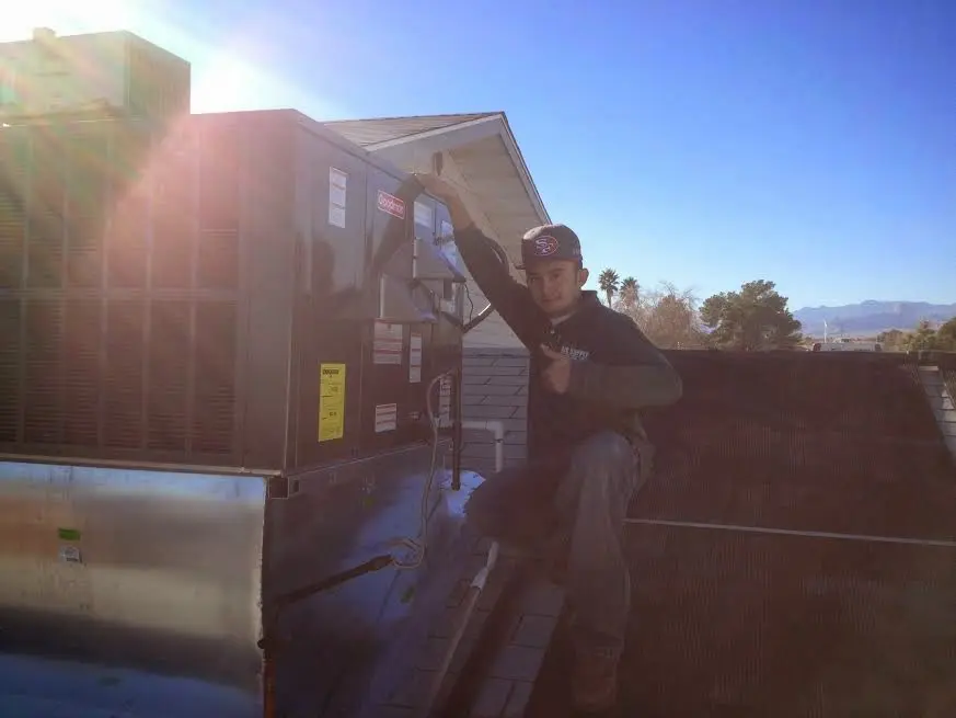 HVAC technician performing Air Duct Cleaning on a rooftop unit in Picayune